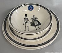 Stack of 3 plates and bowls showing the black border and skeleton bride and groom designs
