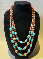 Necklace displayed on black velvet bust showing all three strands