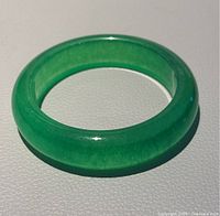 Top-down view of the green jade D-shaped bangle showing color and finish