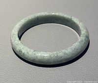 Front angle view of the natural Asian jade D shaped bangle showing the light green jade material with subtle mottling and polished finish.