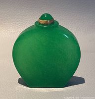 Front view showing smooth, polished green jade snuff bottle with gold-tone screw lid topped by jade dome.