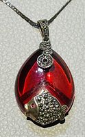 Close-up of the red teardrop-shaped pendant with detailed silver fish motif and marcasite stones.