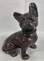 Front angle of the cast iron French Bulldog figurine showing detailed facial features and glossy dark brown finish with black collar and silver studs.