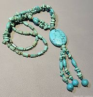 Vintage long turquoise necklace laid out to show full length and bead variety.