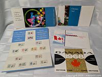 Overview of six Canada Post 1960s mint stamp sets and folders