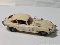 Left side view of cream Dinky Jaguar E-Type with door open