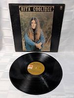 Vinyl record outside sleeve displaying playing surface and center label