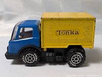 Right side view of blue cab and yellow Tonka cargo box truck