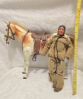 Front view of Tonto figure standing beside Scout horse, with ruler showing height.