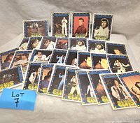 22 collectible Elvis Presley cards laid out fanned in groups on a white cloth background, showing various images and poses of Elvis Presley.