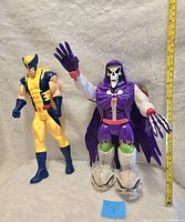 Photo showing Wolverine and Grim Reaper vintage action figures approximately 10-12 inches tall with measuring tape.