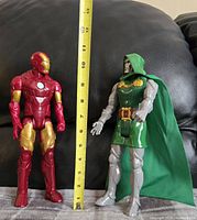 Dr. Doom and Iron Man figures side by side with measuring tape showing approximately 12 inches tall