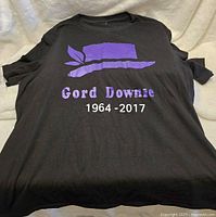 Front view of men's large black T-shirt with purple hat and 'Gord Downie 1964-2017' printed on the front.