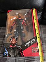 Front view of the Deadshot action figure in original packaging, approximately 11 inches tall.