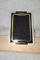 Front of Andrew Cogliano Anthology jersey card showing large black textured jersey swatch with gold and black border.