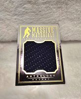 Front view of Panini Anthology hockey card featuring Jason Pominville with embedded large navy blue jersey swatch and gold foil details.