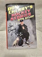Front cover of the book showing Don Cherry in hockey gear, a dog, title text, and Don Cherry's signature with smudging.