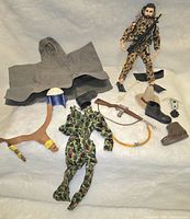 Full shot of Action Jackson and assorted G.I. Joe outfits and accessories spread on white background.