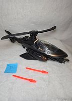 Side view of the black Batcopter toy with two red missiles placed in front