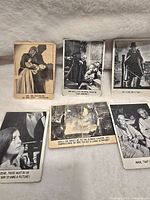 Six vintage black and white monster movie collectible cards spread on a grey fur surface.