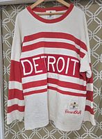 Front view of vintage Detroit Red Wings red and white striped knit jersey sweater with 'DETROIT' lettering and embroidered 'Circa 1930'