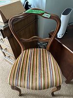 Front view of the wooden balloon back chair showing the curved backrest and striped upholstery seat.