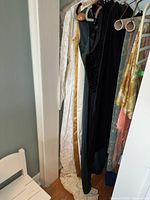 Dresses hanging showing white, gold, black and floral fabric dresses