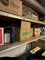 Shelf showing three cardboard boxes labeled Solar LED Pucks