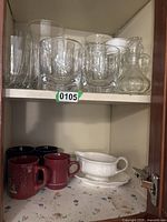 Clear glassware on upper shelf; various sizes and shapes including small pitcher