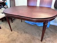 Front view of oval dining table with both removable leaves in place