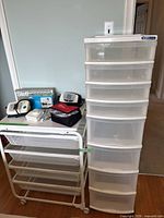 View of plastic organizer with 8 drawers next to metal organizer with 4 mesh drawers, blood pressure machine, and other medical items on top of metal organizer