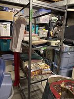 Full view of the Origami folding wire rack loaded with various boxes and items, showing the rack's size and use in storage.