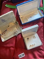 Three jewelry boxes showing multiple cultured pearl necklaces and earrings