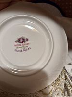 Bottom of a Royal Albert Sweet Violets plate showing floral violet design with "Royal Albert Bone China England Sweet Violets" stamp.