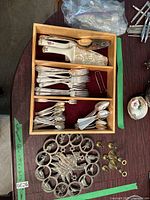 Top view of wooden tray with assorted silverware forks, spoons and serving utensils arranged in compartments