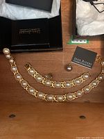 Two gold-tone bracelets with large faux pearls shown with Joan Rivers Classics Collection boxes.