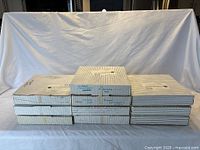 Stack of nine striped boxes containing collector plates on a table