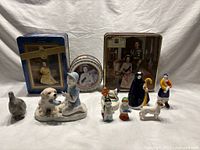 Mixed lot with Queen Elizabeth II commemorative tins and assorted collectible figurines, including porcelain, ceramic, and soapstone.
