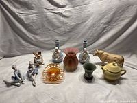 Full lot of porcelain and glass figurines and items including ballerinas, terrier, bull, vase, and dishes.