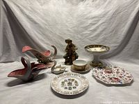 Photo of the entire lot showing various ceramic and pottery items including plates, bowls, figurine, and planters.