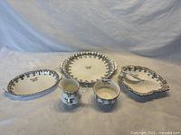 Full set of Royal Albert 25th Anniversary bone china items arranged including handled plate, nappy dish, sugar bowl, creamer, mint dish.