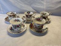 Five Royal Albert bone china teacup and saucer sets with floral and seasonal designs, shown together.