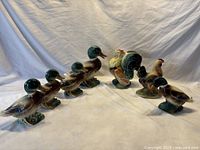 Photo of the full set showing multiple ceramic bird figurines including mallards, rooster and hen.