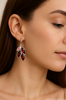 Photo of a woman wearing one of the earrings, showing the earrings hanging and the color and shape of the stones.