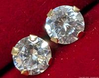 Close-up of the front view of a cubic zirconia stone set in 14KT gold prongs in one earring.