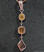 Pendant front view showing three bezel-set diamonds in rhodium-plated 14K white gold.