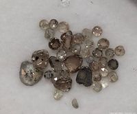 Close-up photo of the collection of natural diamonds showing rough and polished stones of various shapes and colors.