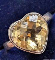 Close-up image of the heart-shaped faceted citrine set in silver ring showing top view.