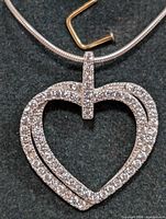 Close-up photo of the heart-shaped sterling silver pendant with cubic zirconia stones on a black background.
