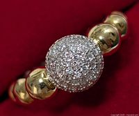 Close-up front view of a size 6.5 ring with a spherical CZ cluster centerpiece set in silver-tone metal and gold-tone bead band.